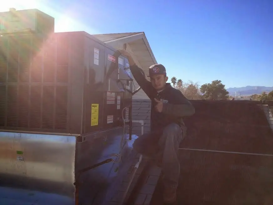HVAC technician performing Boiler Repair on a rooftop unit in Blakely